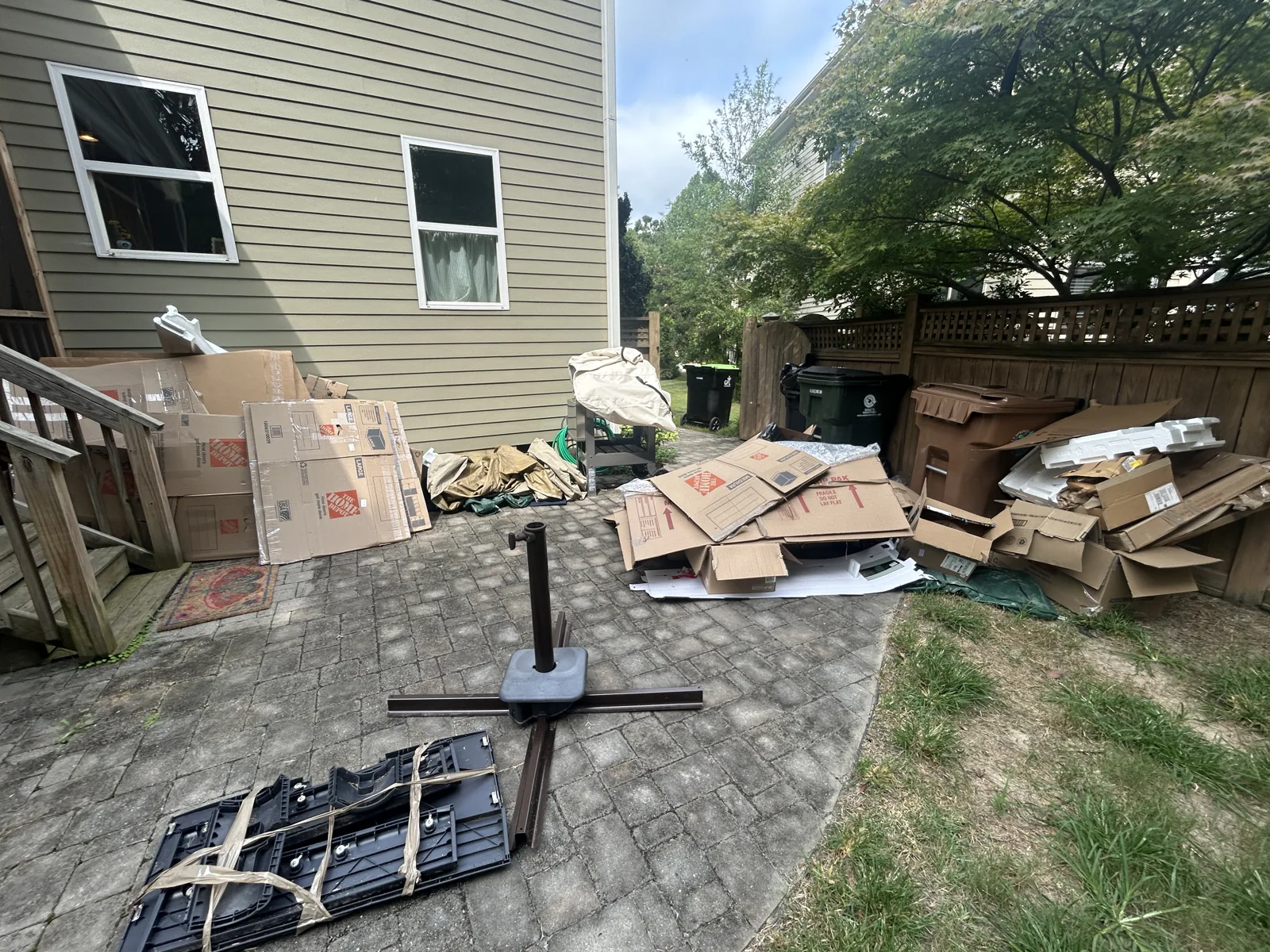 Cardboard boxes and packing materials waiting for removal behind a home — ACG Junk & Debris